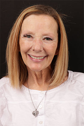 Patient showcasing a radiant smile after complete smile reconstruction with veneers and crowns.